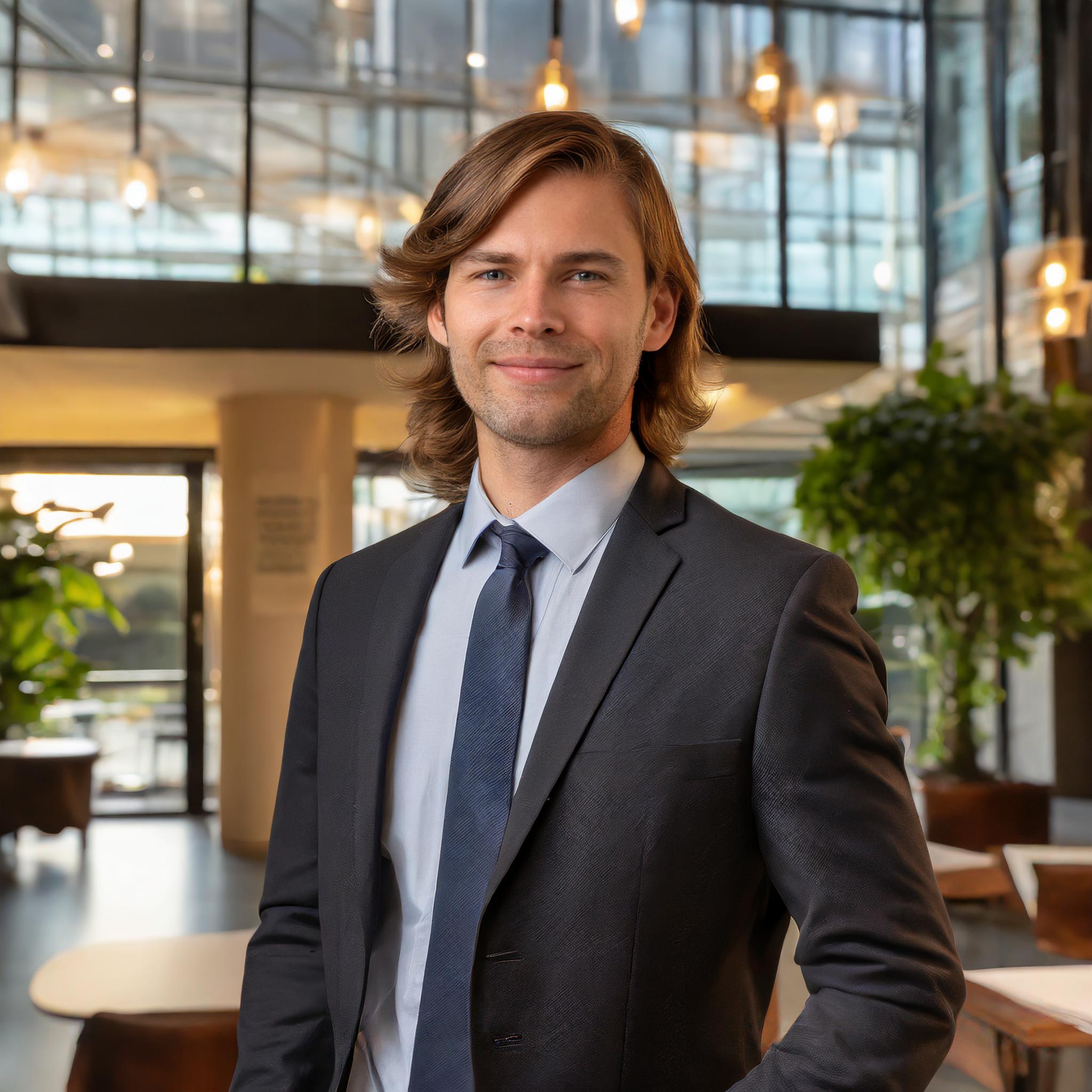 Bernd Rumpf, männlich, lächelnd, in einem formellen Anzug, vor einem modernen Büro